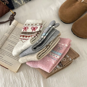 Gros plan de chaussettes en laine tricotées Fair Isle en plusieurs couleurs sur tissu
