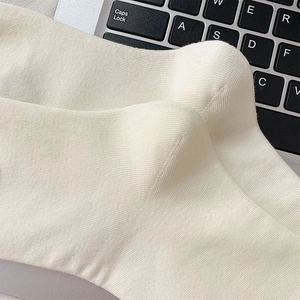 Close-up of off-white ribbed knit socks with high-density cotton and fine stitching detail