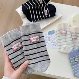 Detail of striped cotton crew socks with woven label showing ribbed cuff and soft texture
