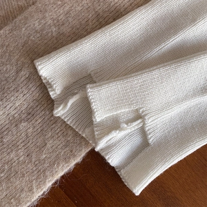 Close-up of white rib-knit leg warmers with side slit detail and soft texture