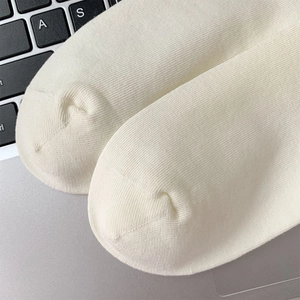 Detailed macro view of the seamless knit toe structure on white cotton crew socks