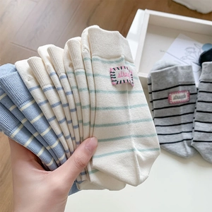 Detail of colorful striped cotton socks with a pink struggle text label on the side
