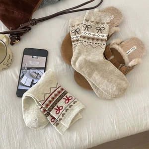 Détail de chaussettes en laine Fair Isle avec nœud rouge et motif jacquard cœur