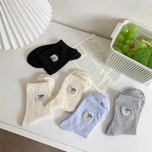 Detail of knit socks with bear embroidery and colorful flecks in four assorted colors
