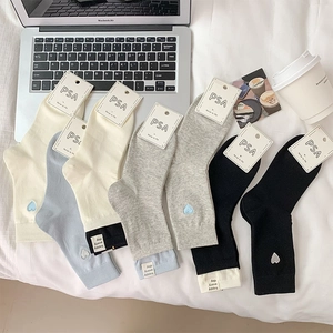 Detail of heart embroidered cotton socks in multi-color set with woven label accents
