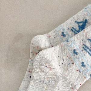 Close-up of Fair Isle wool socks featuring festive patterns and soft speckled knit texture