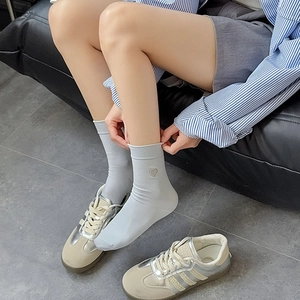 Close-up of heart embroidery on light gray ribbed cotton mid-calf socks for women