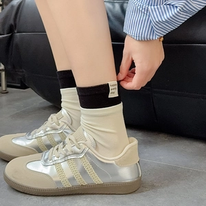 Close-up of heart embroidered crew socks with 'happy every day' label and retro sneakers