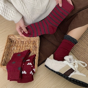 Detail of red striped and polka dot knit crew socks with vintage lace cuffs