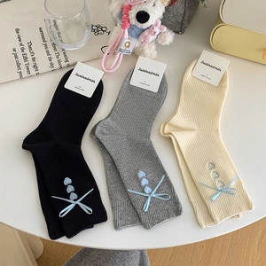 Detail of three-pack cotton socks featuring heart embroidery and blue ribbon bows
