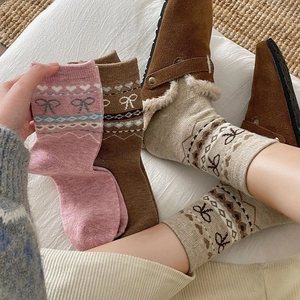 Détail de chaussettes en laine Fair Isle avec nœuds tricotés et motifs de cœurs chauds
