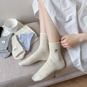Detailed view of knitted ribbed socks featuring cute bear embroidery and speckled texture