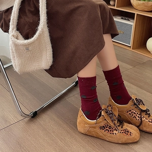 Detail of red polka dot socks paired with leopard print brown suede retro sneakers