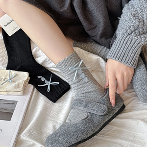 Detail of combed cotton mid-calf socks with ribbon bow and heart embroidery
