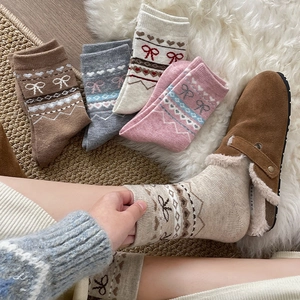 Gros plan de chaussettes épaisses en laine Fair Isle avec motifs vintage et nœuds