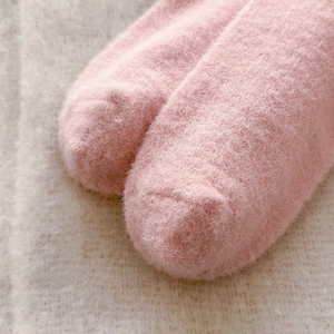 Close-up of soft pink plush coral fleece socks showing thick warm fuzzy texture detail