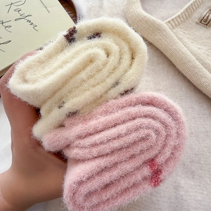 Close-up of thick plush socks showing soft coral fleece texture and polka dot patterns