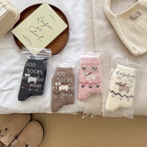Detail of four pairs of warm plush socks with cartoon dog patterns in flat lay view