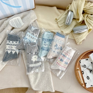 Close-up of five pairs of Nordic Fair Isle wool socks in frosted zipper packaging bags