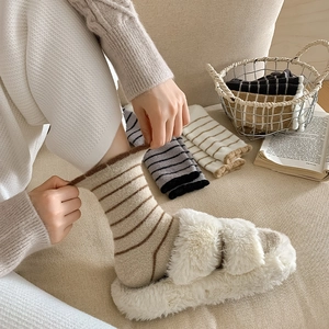 Close-up of thick striped fuzzy socks in brown and beige with knit texture detail