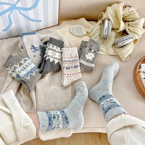 Detailed knit texture of Fair Isle wool socks featuring cute dog and heart patterns