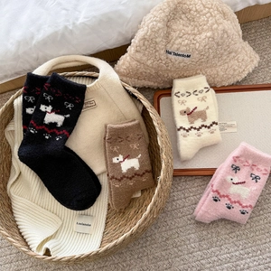 Flat lay of cute dog patterned warm knit socks with a plush hat and scarf set