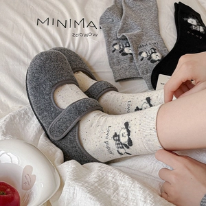 Chaussons style japonais en feutre gris avec chaussettes Love Puppy sur literie blanche