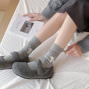 Detail of gray cotton mid-tube socks with white alpaca and heart pattern in soft fabric