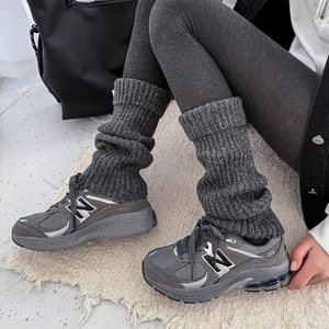 Women's dark grey cable knit leg warmers paired with retro mesh suede sneakers
