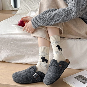 Close-up of dark grey felt mules with a metal buckle and cute heart pattern socks