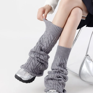 Close-up of grey cable-knit leg warmers showing intricate texture and soft knit material