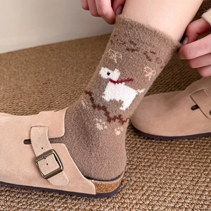 Detail of warm brown knit socks with a white puppy pattern and red scarf accents