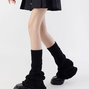 Detail of black cable knit leg warmers paired with chunky loafers for a schoolgirl look