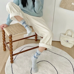 Close-up of Fair Isle patterned light blue wool socks with ribbed cuffs and puppy motif