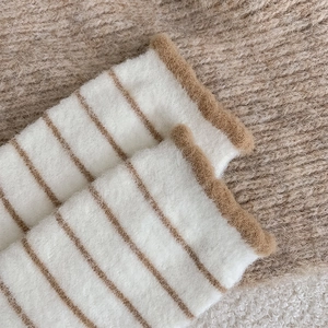 Detail of warm striped fleece socks with brown ruffled edges and cozy plush texture
