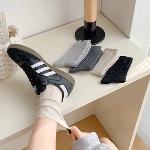Detail of ribbed knit texture on cream and grey melange cotton crew socks for women