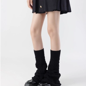 Detail of black knit leg warmers with cable knit texture and ribbed cuffs for women