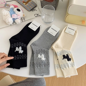 Detailed view of three combed cotton socks in black, grey and beige with poodle patterns