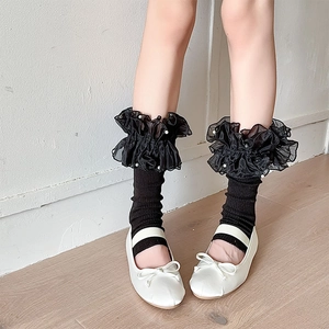 Detail of Lolita leg warmers featuring black organza ruffles and delicate white pearls