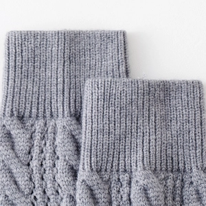 Macro shot of grey cable knit leg warmer detailing soft texture and ribbed cuffs