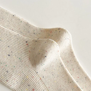 Detail of ribbed knit crew socks in cream with colorful confetti speckle pattern