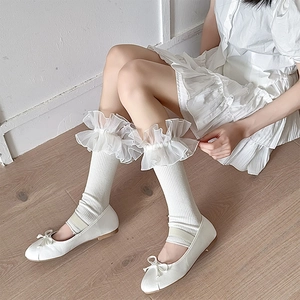 Detail of white Lolita leg warmers featuring layered organza ruffles and pearl beads