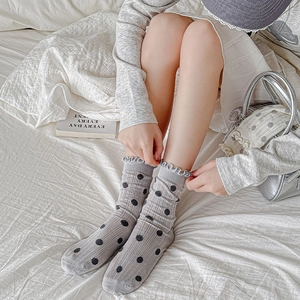 Grey ballet style crew socks with black polka dots and ruffled edges for women