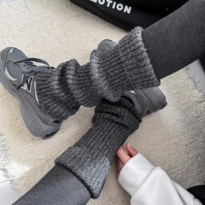 Detail of dark grey knit leg warmers with snowflake speckle pattern and thick rib texture