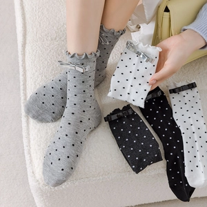Détail de chaussettes mi-mollet douces avec bords volantés et nœuds délicats