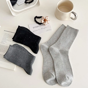 Close-up of confetti knit socks in gray and black with subtle vertical stripe texture