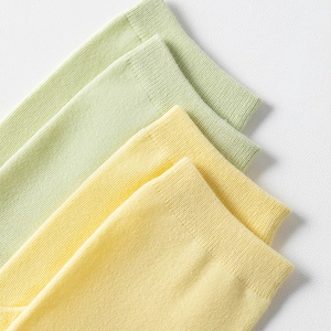 Detail of ribbed cuffs on candy-colored tabi socks in pastel green and yellow cotton fabric