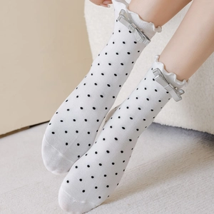 Chaussettes blanches à pois noirs avec bords à volants et nœuds en métal argenté