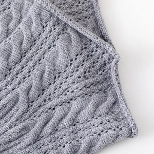 Macro shot of grey cable knit leg warmers showing detailed texture and hollow patterns