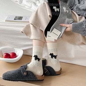 Detail of knit crew socks with cute heart and dog patterns paired with felt clogs